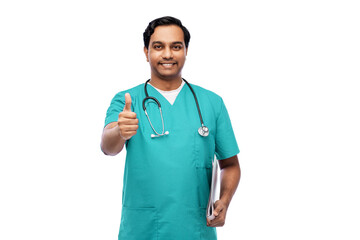 healthcare, profession and medicine concept - happy smiling indian doctor or male nurse in blue uniform with stethoscope showing thumbs up over white background