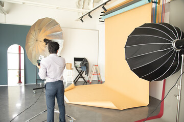 man adjusting light in photography studio.