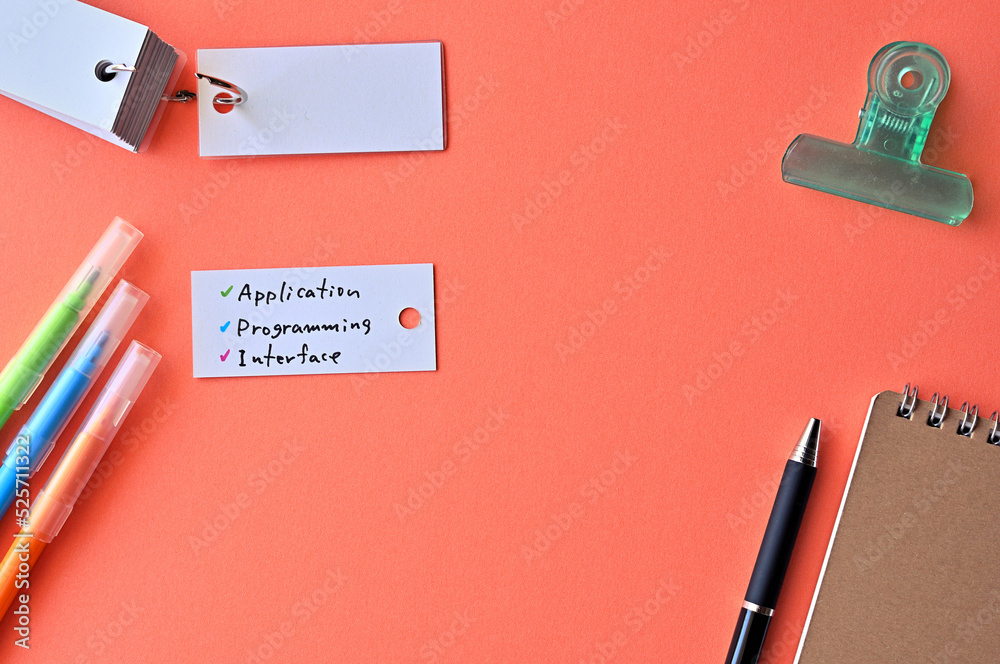 Poster there is word card with the word application programming interface on the desk.
