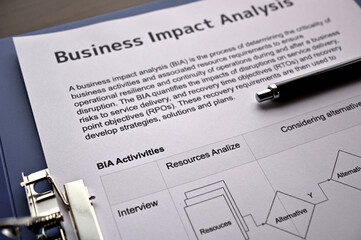 There is dummy documents that created for the photo shoot on the desk about Business Impact Analysis.