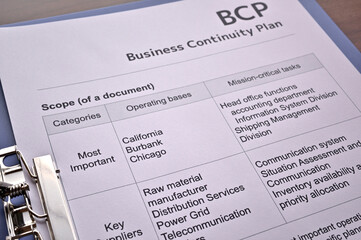 There is dummy documents that created for the photo shoot on the desk about Business Continuity Plan.