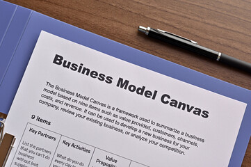 There is dummy documents that created for the photo shoot on the desk about Business Model Canvas.