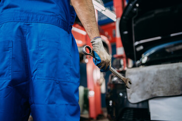 Fototapeta na wymiar Close up of view auto mechanic repairman holding a wrench prepare to fix the car, check the mileage of the car, oil change, auto repair service center.