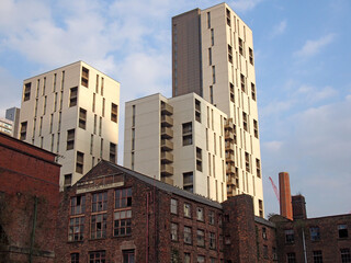 modern highrise apartment developments behind old abandoned industrial buildings in manchester city centre