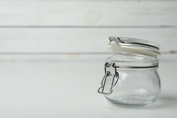 Empty glass jar on white table, space for text