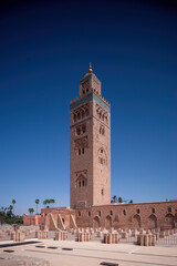 Fototapeta premium Koutoubia Mosque Minaret in Morocco Marrakesh and gardens during sunset with blue sky. Inside Medina.