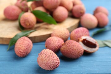 Fresh ripe lychee fruits on blue wooden table