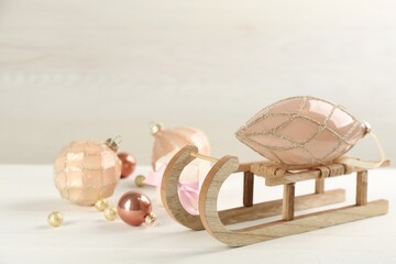 Beautiful Christmas composition with miniature sleigh on white table. Space for text