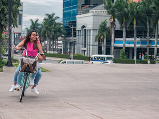  Portrait of two Hispanic friends riding a bicycle through the center of the city of El Salvador.