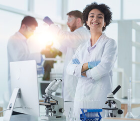 Smiling scientists looking at camera arms crossed in laboratory