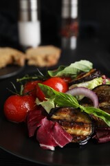 Delicious salad with roasted eggplant and basil on plate, closeup
