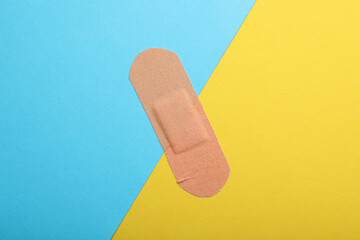 Sticking plaster on color background, top view