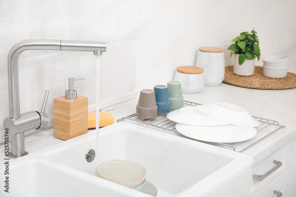 Sticker Drying rack with clean dishes near sink in stylish kitchen