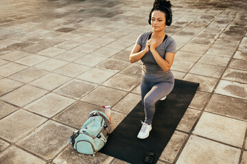 Fitness girl doing lunge in urban park