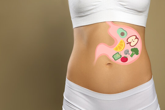 Woman with image of stomach full of food drawn on her belly against beige background, closeup. Healthy eating habits
