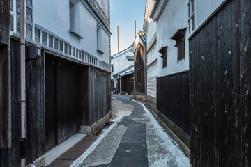 A back alley in Kurashiki Bikan Historical Quarter in sunny day. The town of Shirakabe (Namakokabe) concept