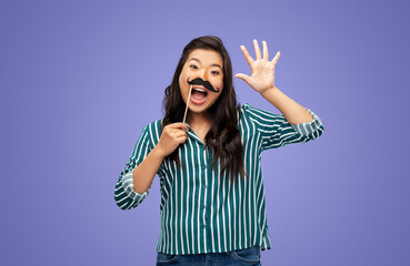 party props, photo booth and people concept - happy woman with big black moustaches waving hand over violet background