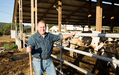 Portrait of confident senior man owner of dairy farm