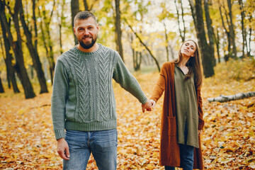 Beautiful couple spend time in a autumn park