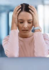 Stressed, tired and sick young woman with a headache feeling sad and overworked in an office. A...