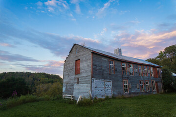 old abandoned farm house under sunset