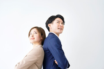 白背景に背中合わせで腕組みをして立つビジネスウーマンとビジネスマン