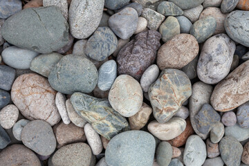 Large stones of different shapes on the riverbank close-up. there are a lot of small stones nearby.