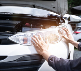 Car mechanical engineering checking headlight by customer claim order at workshop garage.