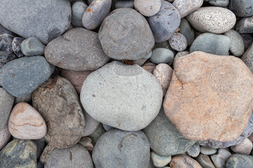 Large stones of different shapes on the riverbank close-up. there are a lot of small stones nearby.