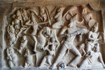 Battlefield scene of Hindu Goddess Durga fight with the Buffalo headed Demon with her army of female warriors is carved as Bas relief sculpture in the rock cut cave temples in Mahabalipuram, Tamilnadu