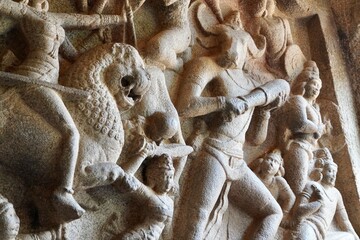 Battlefield scene of Hindu Goddess Durga fight with the Buffalo headed Demon with her army of female warriors is carved as Bas relief sculpture in the rock cut cave temples in Mahabalipuram, Tamilnadu