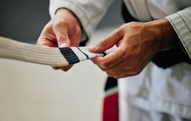 .Fitness, training and karate teacher hands prepare uniform for new student at a center or dojo. Martial arts sensei getting ready to lead a lesson on self defense, speed and physical endurance. © Delcio Fernandes/peopleimages.com
