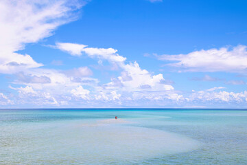 遠浅の海に人が立っている風景