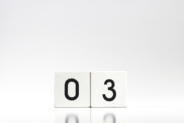White wooden block with number 03 with reflection isolated on white background