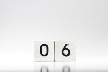 White wooden block with number 06 with reflection isolated on white background