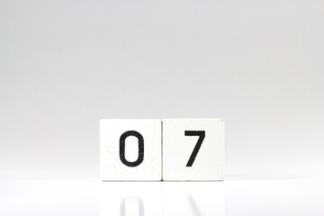 White wooden block with number 07 with reflection isolated on white background