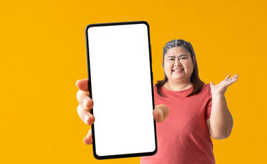 Happy asian fat woman holding big smartphone on yellow background, isolated Clipping paths for...
