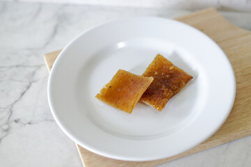 Fried pork skin on a white plate. Pig food culinary cuisine.