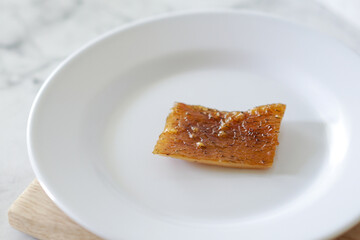 Fried pork skin on a white plate. Pig food culinary cuisine.