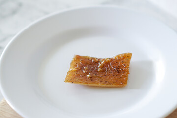 Fried pork skin on a white plate. Pig food culinary cuisine.