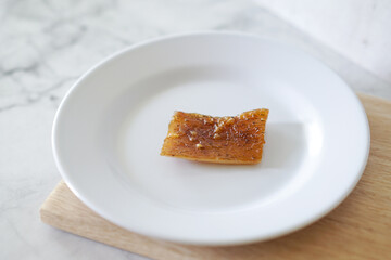 Fried pork skin on a white plate. Pig food culinary cuisine.