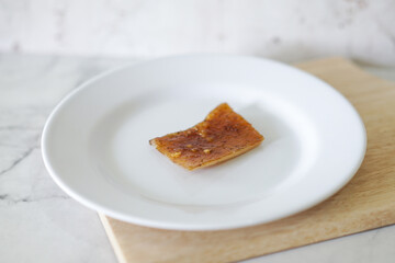 Fried pork skin on a white plate. Pig food culinary cuisine.