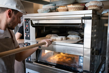 The process of making traditional French bread in an artisan bakery. Bordeaux Corona baking. Front...