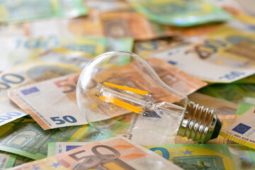  light bulbs on euro bills.Rising electricity prices in Europe.Crisis of energy production in the EU countries.Increasing the cost of light and heat.Saving electricity concept