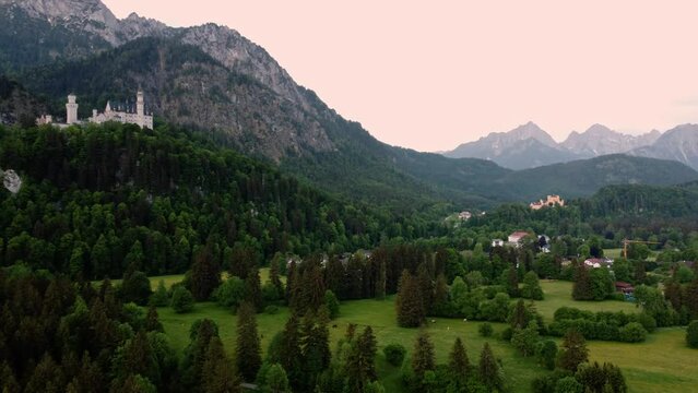 Dawn at Neuschwanstein Castle near Fussen in southwest Bavaria, Germany. Historic landmark palace near the Alps, surrounded by forest, mountains, and wide plains - 4K 30fps Smooth Rotating Right