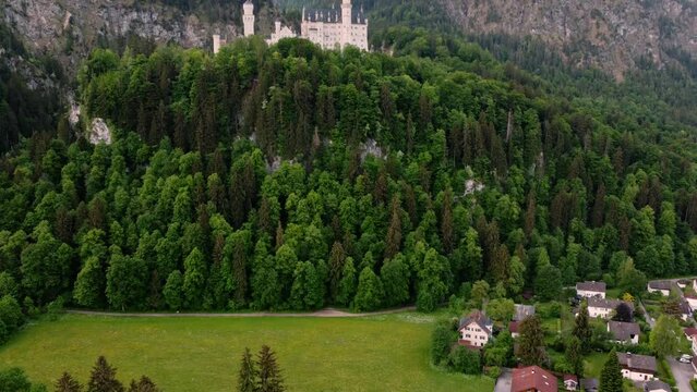 Dawn at Neuschwanstein Castle near Fussen in southwest Bavaria, Germany. Historic landmark palace near the Alps, surrounded by forest, mountains, and wide plains - 4K 30fps Smooth Panning Up