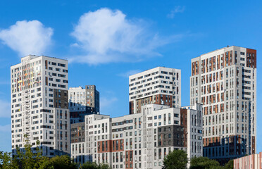 Fototapeta premium Monolithic residential apartment block buildings district on blue sky