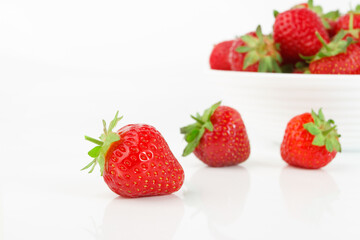 Red ripe strawberry in the white bowl