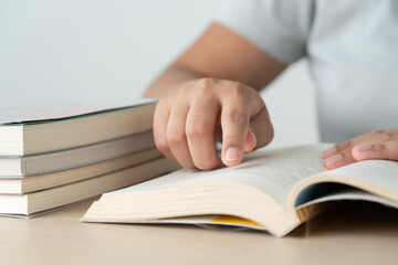 Literacy and education concept woman reading book and book stack on desk