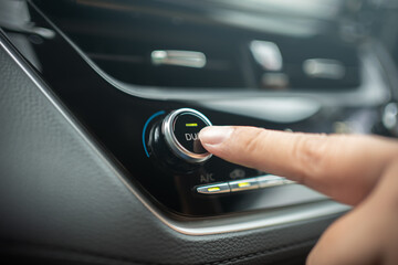 Naklejka premium Driver adjusting car air conditioner system at interior panel